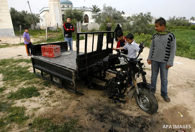 A Palestinian man reacts next to a rickshaw following an Israeli air strike in Khan Younis in the southern Gaza Strip on March 12, 2012. Israeli air strikes killed two Palestinian militants and wounded 25 civilians in th...