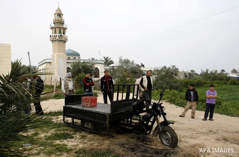 A Palestinian man reacts next to a rickshaw following an Israeli air strike in Khan Younis in the southern Gaza Strip on March 12, 2012. Israeli air strikes killed two Palestinian militants and wounded 25 civilians in th...