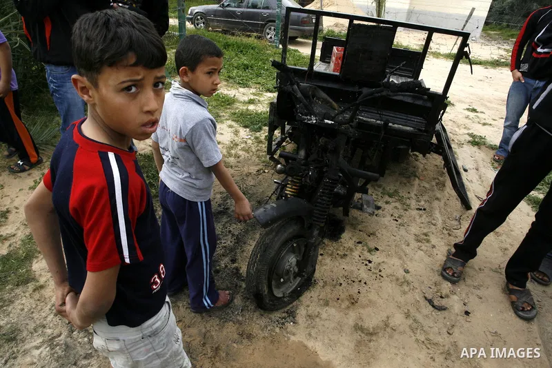 A Palestinian man reacts next to a rickshaw following an Israeli air strike in Khan Younis in the southern Gaza Strip on March 12, 2012. Israeli air strikes killed two Palestinian militants and wounded 25 civilians in th...