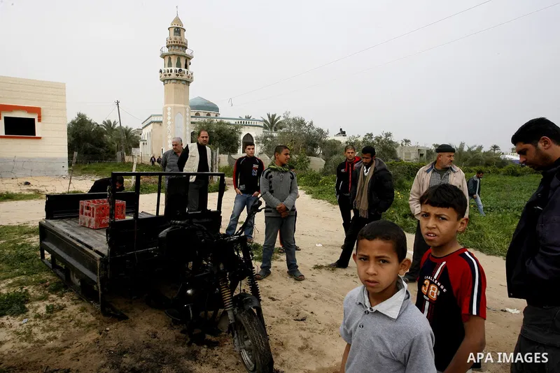 A Palestinian man reacts next to a rickshaw following an Israeli air strike in Khan Younis in the southern Gaza Strip on March 12, 2012. Israeli air strikes killed two Palestinian militants and wounded 25 civilians in th...