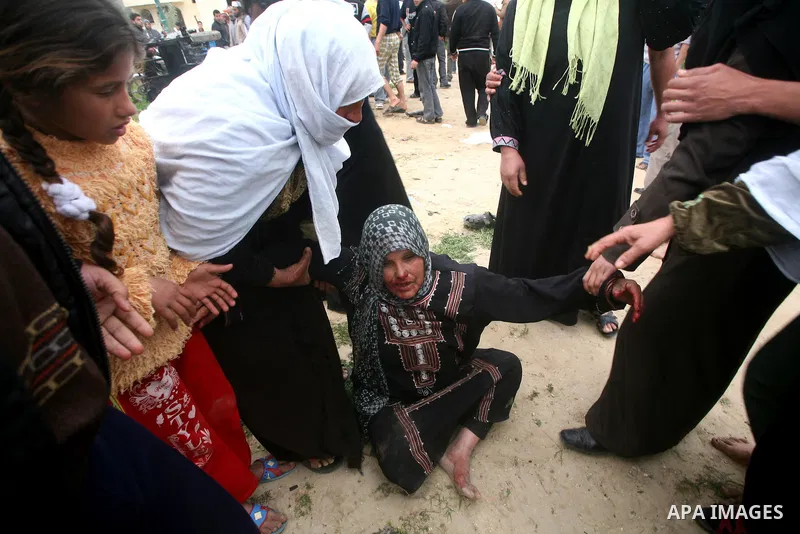 The mother of a Palestinian militant mourns next to his body (not seen) at the scene of an Israeli air strike in Khan Younis in the southern Gaza Strip March 12, 2012. Israeli air strikes killed two Palestinian militants...