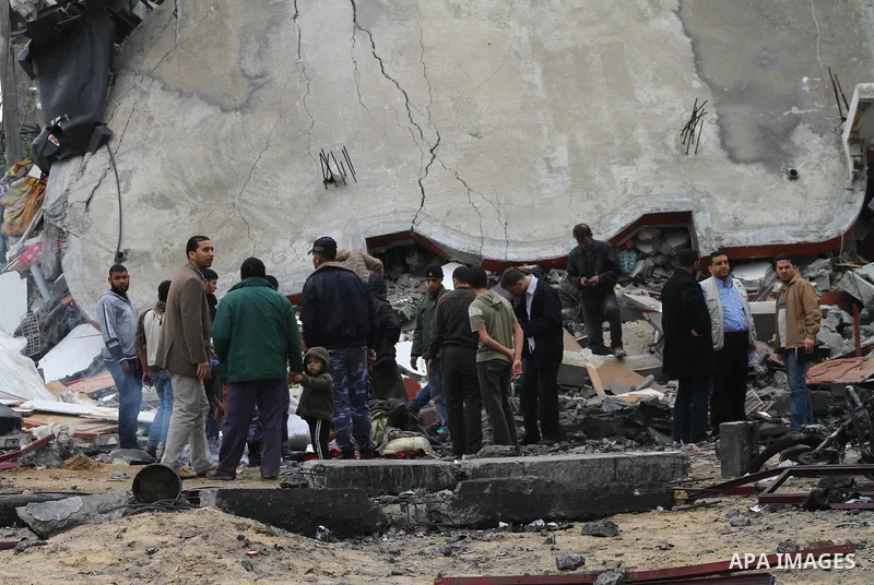 Palestinians inspect the destruction after an Israeli air strike on a building in the northern Gaza Strip refugee camp of Jabalia on March 12, 2012. Israel launched a spate of air strikes killing at least two Palestinian...