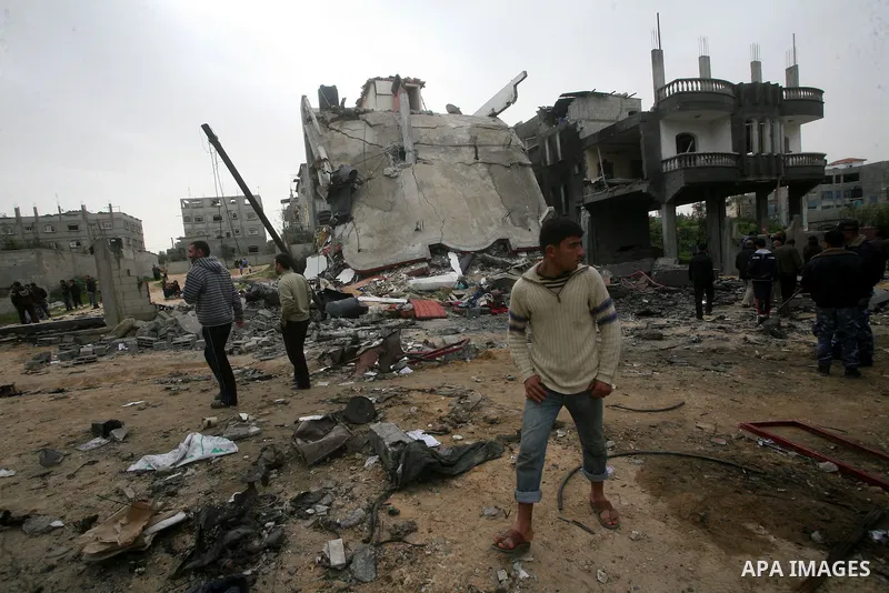 Palestinians inspect the destruction after an Israeli air strike on a building in the northern Gaza Strip refugee camp of Jabalia on March 12, 2012. Israel launched a spate of air strikes killing at least two Palestinian...