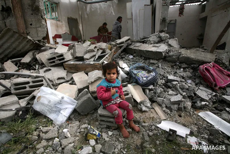 A Palestinian child sit in front of their house, destroyed after an Israeli air strike in Jabalya in the northern Gaza Strip. A recent wave of Israel bombings have reported to have killed at least 20. Photo by Ashraf Amr...