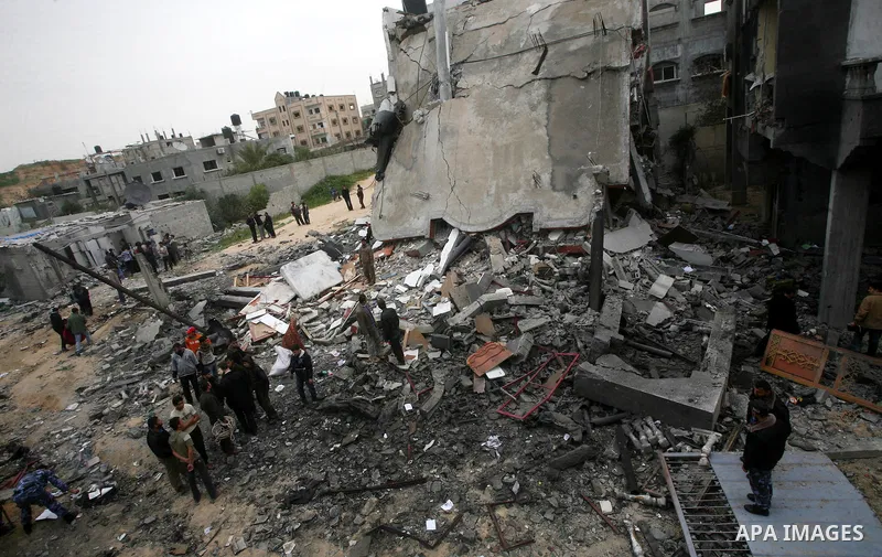 Palestinians inspect the destruction after an Israeli air strike on a building in the northern Gaza Strip refugee camp of Jabalia on March 12, 2012. Israel launched a spate of air strikes killing at least two Palestinian...