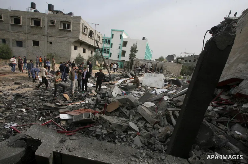 Palestinians inspect the destruction after an Israeli air strike on a building in the northern Gaza Strip refugee camp of Jabalia on March 12, 2012. Israel launched a spate of air strikes killing at least two Palestinian...