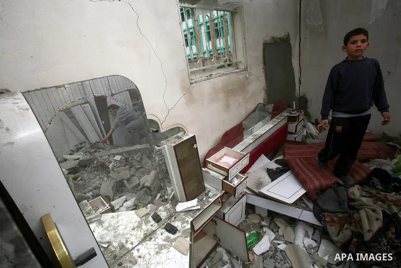 A Palestinians boy inspects the destruction after an Israeli air strike on a building in the northern Gaza Strip refugee camp of Jabalia on March 12, 2012. Israel launched a spate of air strikes killing at least two Pale...