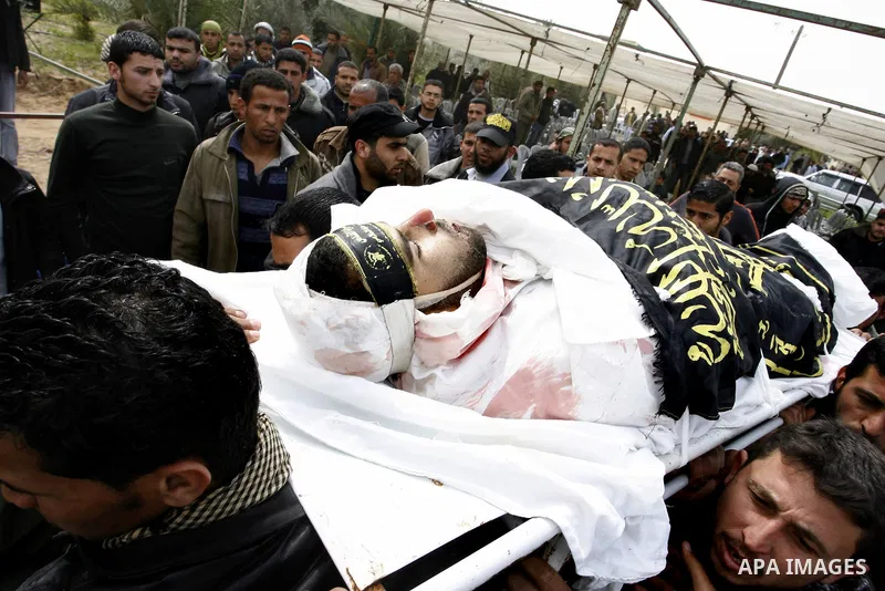 Palestinian mourners carry the body of Raafat Abu Eid , 24-years-old, a member of the Islamic Jihad's armed wing, the Al-Quds Brigades, during his funeral in Khan Yunis in the southern Gaza Strip, on March 12, 2012. Eid...