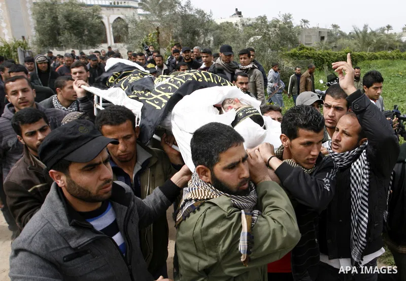 Palestinian mourners carry the body of Raafat Abu Eid , 24-years-old, a member of the Islamic Jihad's armed wing, the Al-Quds Brigades, during his funeral in Khan Yunis in the southern Gaza Strip, on March 12, 2012. Eid...