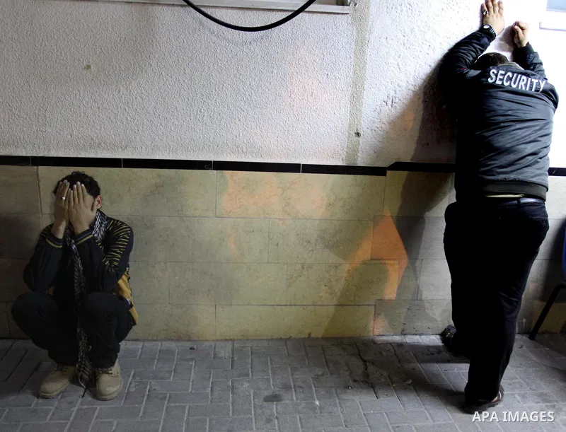 Two Palestinian youths mourn outside Gaza City's Al-Shifa hospital where the bodies of two Islamic Jihad militants, who were killed in an Israeli airstrike on March 12, 2012, were delivered, as Israeli warplanes pounded...