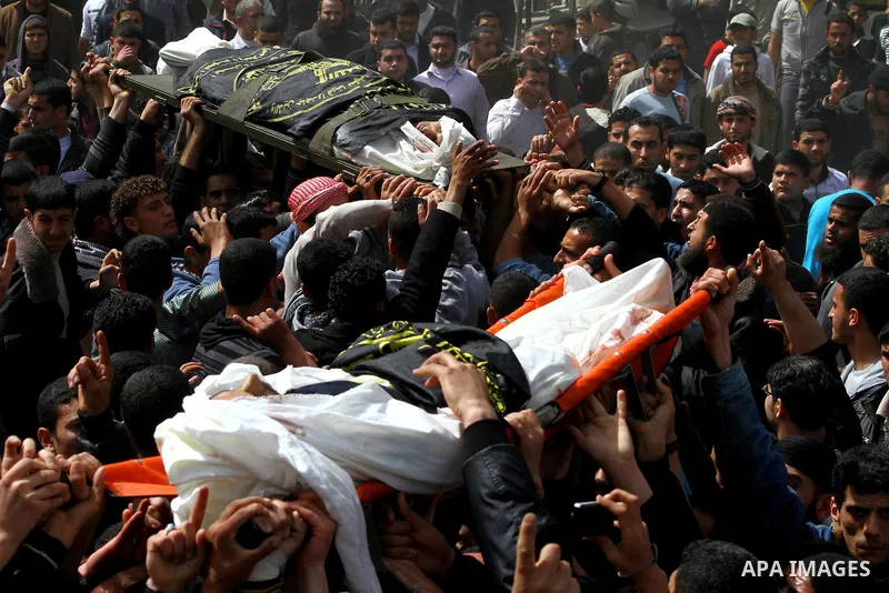 Palestinian mourners carry the bodies of two Islamic Jihad militants killed in Israeli strikes on Gaza Tuesday, during their funeral in Gaza City, Tuesday, March 13, 2012 . Israel halted its airstrikes against Gaza Strip...
