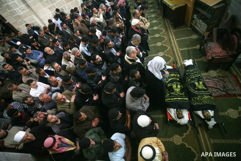 Palestinians pray on the bodies of two Islamic Jihad militants Mohammed Daher, left, and Bassam Al Ejla killed in an Israeli air strike in Gaza Tuesday, during their funeral in Gaza City, Tuesday, March 13, 2012 . Israel...