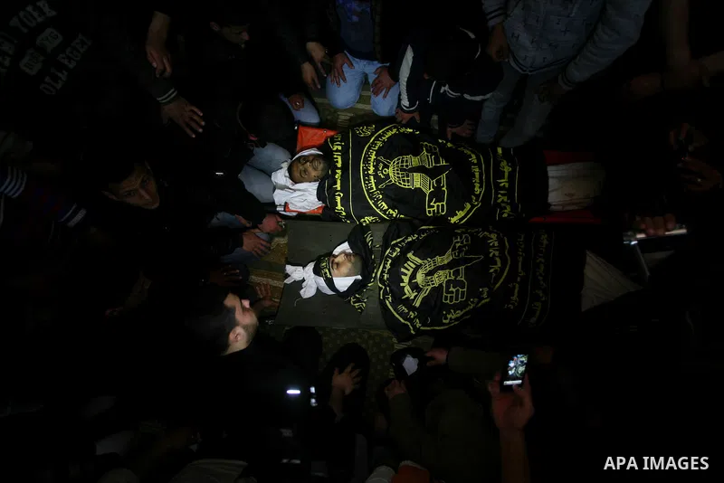 Palestinians mourn beside the bodies of two Islamic Jihad militants Mohammed Daher, left, and Bassam Al Ejla killed in an Israeli air strike in Gaza Tuesday, during their funeral in Gaza City, Tuesday, March 13, 2012 . I...