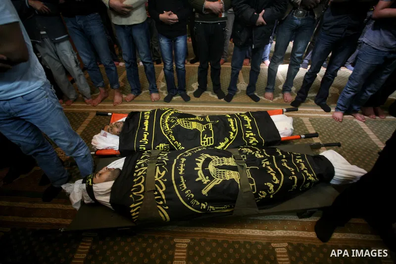 Palestinians pray on the bodies of two Islamic Jihad militants Mohammed Daher, left, and Bassam Al Ejla killed in an Israeli air strike in Gaza Tuesday, during their funeral in Gaza City, Tuesday, March 13, 2012 . Israel...