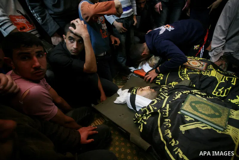 Palestinians mourn beside the bodies of two Islamic Jihad militants Mohammed Daher, left, and Bassam Al Ejla killed in an Israeli air strike in Gaza Tuesday, during their funeral in Gaza City, Tuesday, March 13, 2012 . I...