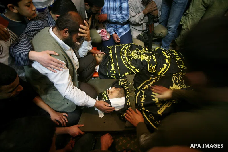 Palestinians mourn beside the bodies of two Islamic Jihad militants Mohammed Daher, left, and Bassam Al Ejla killed in an Israeli air strike in Gaza Tuesday, during their funeral in Gaza City, Tuesday, March 13, 2012 . I...