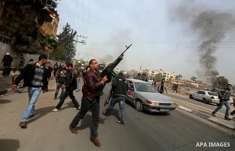 A Palestinian fires a weapon in the air during the funeral of Islamic Jihad militant Mohammed Daher in Gaza City March 13, 2012. An Egyptian-brokered truce between Israel and militant groups in the Gaza Strip began to ta...