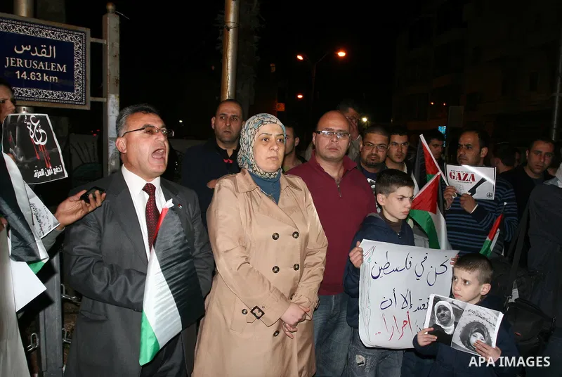 Palestinians take part in a protest in the center of the West Bank city of Ramallah on Mar. 13, 2012, to show their support for the Gaza Strip and against Israeli air strikes. Israel will continue air strikes against Gaz...