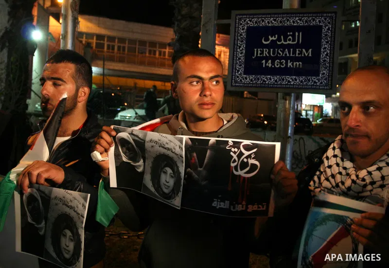 Palestinians take part in a protest in the center of the West Bank city of Ramallah on Mar. 13, 2012, to show their support for the Gaza Strip and against Israeli air strikes. Israel will continue air strikes against Gaz...