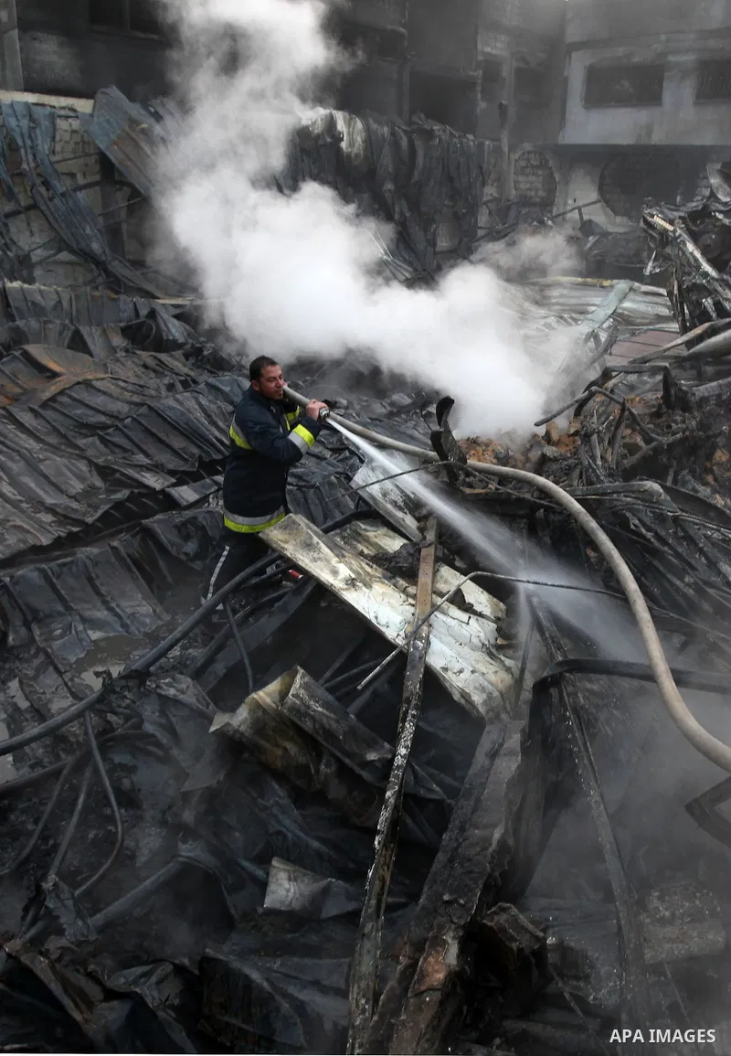 Palestinian firemen extinguish a fire at a building on March 14, 2012, after an Israeli air strike on Gaza City. Israel and militants in Gaza began observing an Egyptian-brokered truce on March 13, after four days of vio...