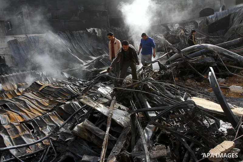 Palestinians inspect destroyed buildings on March 14, 2012, following an Israeli air strike on Gaza City. Israel and militants in Gaza began observing an Egyptian-brokered truce on March 13, after four days of violence,...