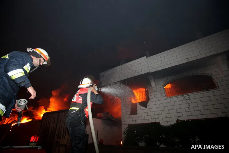 Palestinian fire fighters try to extinguish a blaze at a burning factory after an Israeli missile strike in the east of Gaza Strip on 14 March 2012. A fragile truce appeared to be taking hold between Israel and Palestini...