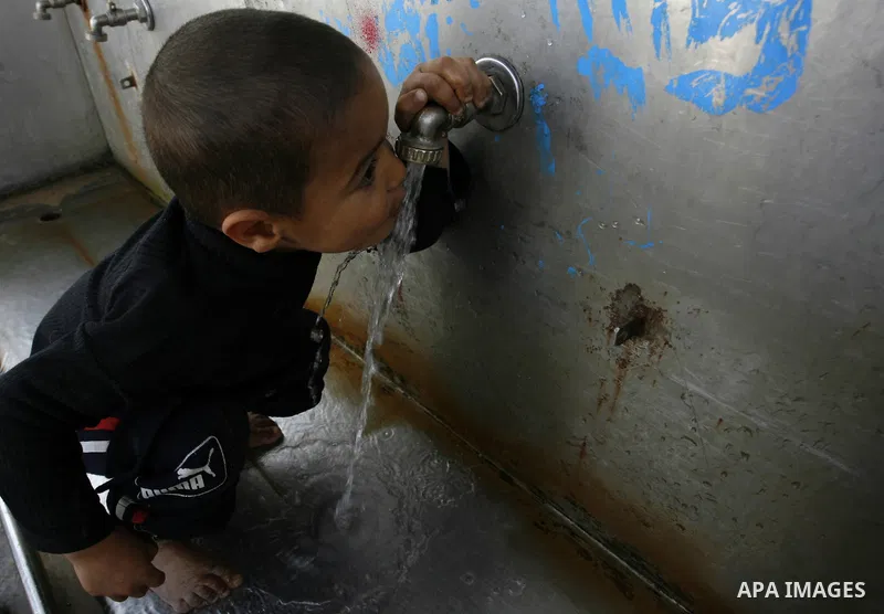 A Palestinian child drinks the water from tap at the United Nations Relief and Works Agency (UNRWA) headquarters in the southern Gaza Strip refugee camp of Rafah on March 14, 2012. The Palestinian Authority pushed plans...