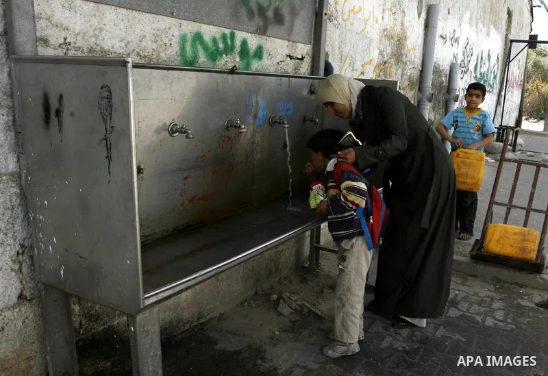 A Palestinian child drinks the water from tap at the United Nations Relief and Works Agency (UNRWA) headquarters in the southern Gaza Strip refugee camp of Rafah on March 14, 2012. The Palestinian Authority pushed plans...
