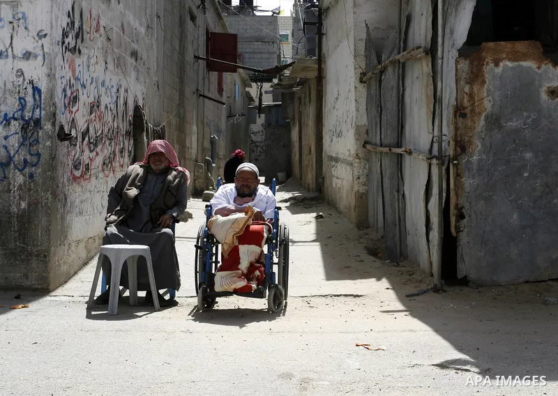 Palestinians refugee sit in front his house in the Rafah refugee camp on May 14, 2012. Photo by Abed Rahim Khatib