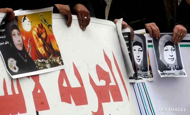 Palestinian protestors demonstrate at the entrance to Ofer Prison near Ramallah in the Occupied West Bank to support female prisoner Hanaa al-Shalabi (portrait) who was freed in a prisoner swap with Israel but was re-arr...