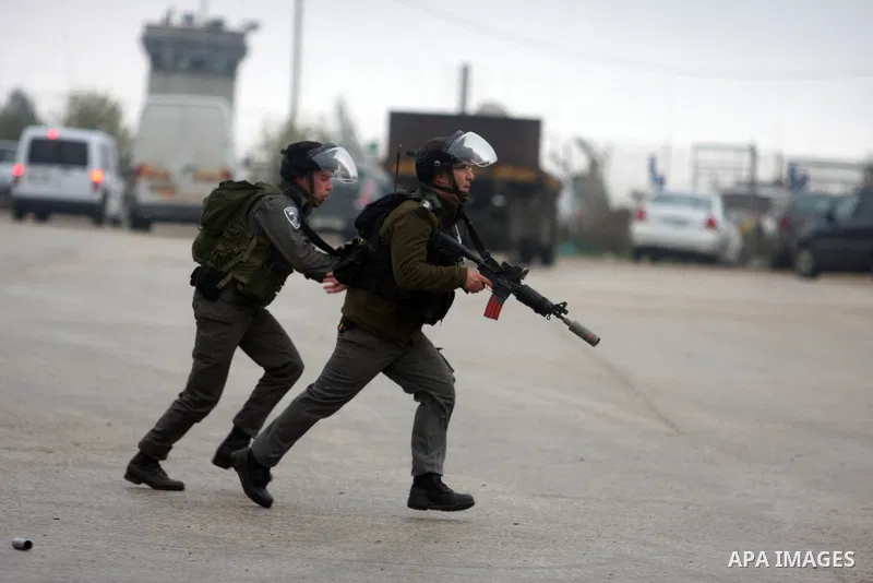 Palestinian protestors clash with Israeli soldiers at the entrance to Ofer Prison near Ramallah in the Occupied West Bank during a demonstration to support female prisoner Hanaa al-Shalabi (portrait) who was freed in a p...