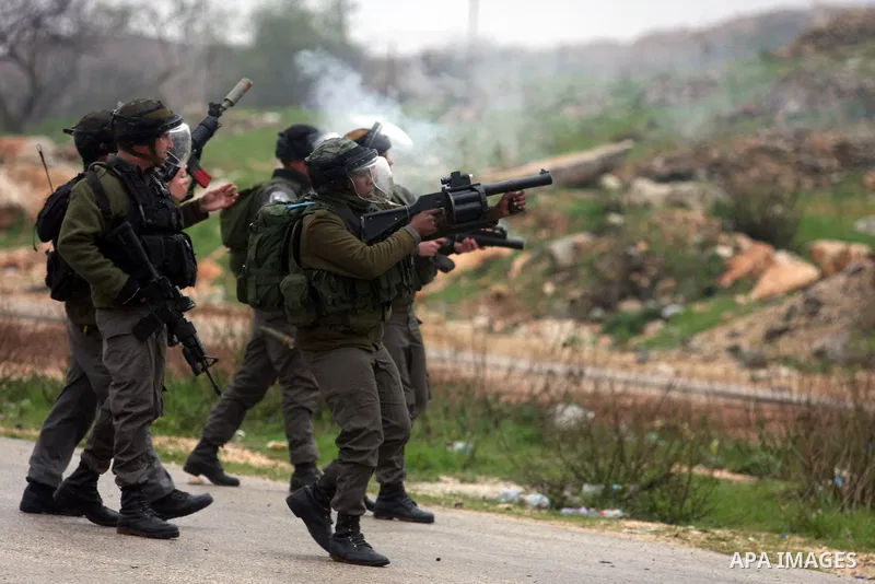 Palestinian protestors clash with Israeli soldiers at the entrance to Ofer Prison near Ramallah in the Occupied West Bank during a demonstration to support female prisoner Hanaa al-Shalabi (portrait) who was freed in a p...