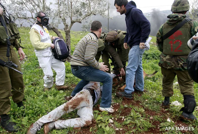 An Israeli army dog attacks a Palestinian protester during a demonstration against the expropriation of Palestinian land by Israel in the village of Kafr Qaddum, near Nablus in the occupied West Bank, on March 16, 2012....