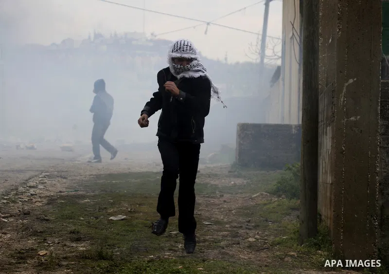 Palestinian youths hurl stones at Israeli security forces ,during a protest in the village of Kufr Qaddum near the Israeli settlement of Kdumim, in the northern West Bank, Friday,March 16, 2012. Photo by Wagdi Eshtayah