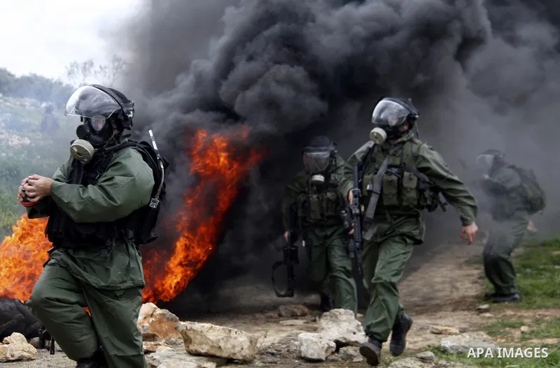 Israeli border police run towards Palestinian demonstrators, during a protest in the village of Kufr Qaddum near the Israeli settlement of Kdumim, in the northern West Bank, Friday,March 16, 2012. Photo by Wagdi Eshtayah
