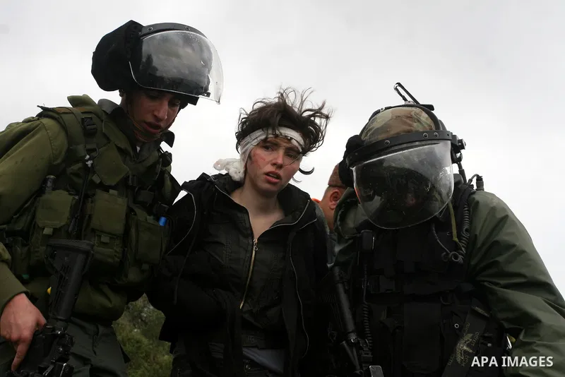 Naomi Laet, 22, an Israeli pro-Palestinian activist, is treated by Israeli security force officers after she sustained a head injury from a rubber bullet fired by the forces during clashes with Palestinian stone-throwers...