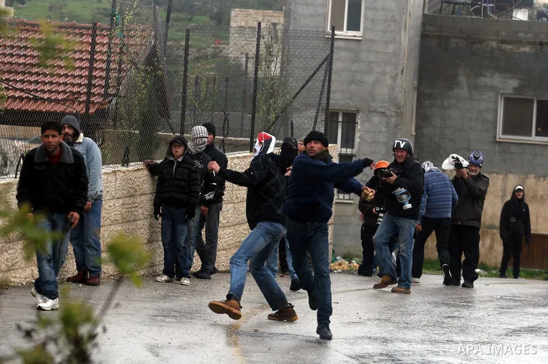 A Palestinian protester hurls a stone at Israeli soldiers during a protest in the West Bank village of Nabi Saleh, near Ramallah, on March 16, 2012 against the confiscation of Palestinian land to build the Jewish settlem...
