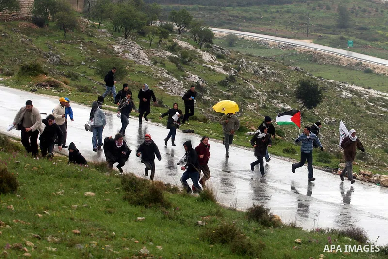 A Palestinian protester hurls a stone at Israeli soldiers during a protest in the West Bank village of Nabi Saleh, near Ramallah, on March 16, 2012 against the confiscation of Palestinian land to build the Jewish settlem...