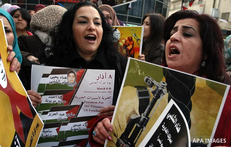 Palestinian women hold portraits of jailed compatriot Hana Shalabi, a female Palestinian prisoner jailed in Israel who has been on hunger strike for 26 days, outside the Red Cross building in the West Bank city of Hebron...