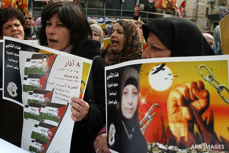Palestinian women hold portraits of jailed compatriot Hana Shalabi, a female Palestinian prisoner jailed in Israel who has been on hunger strike for 26 days, outside the Red Cross building in the West Bank city of Hebron...
