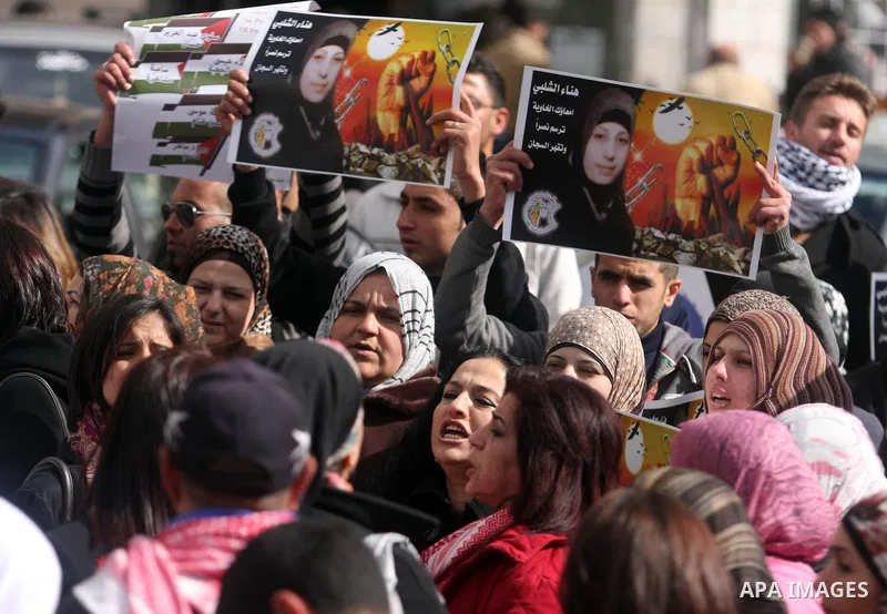 Palestinian women hold portraits of jailed compatriot Hana Shalabi, a female Palestinian prisoner jailed in Israel who has been on hunger strike for 26 days, outside the Red Cross building in the West Bank city of Hebron...