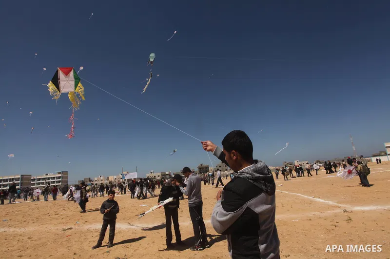 Palestinian children fly kites to show their solidarity with the Japanese people near a Japanese-funded housing project in Khan Younis in the southern Gaza Strip March 18, 2012. The event was organized by the United Nati...