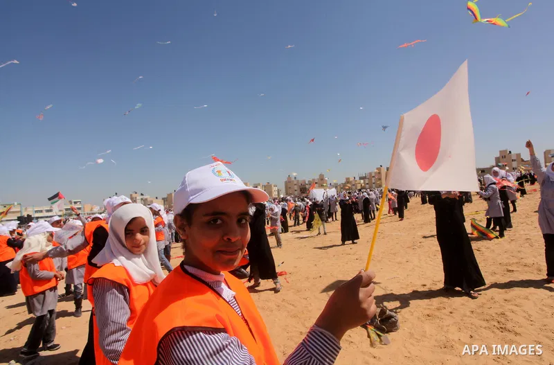 Palestinian children fly kites to show their solidarity with the Japanese people near a Japanese-funded housing project in Khan Younis in the southern Gaza Strip March 18, 2012. The event was organized by the United Nati...