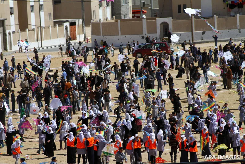 Palestinian children fly kites to show their solidarity with the Japanese people near a Japanese-funded housing project in Khan Younis in the southern Gaza Strip March 18, 2012. The event was organized by the United Nati...