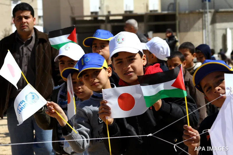 Palestinian children fly kites to show their solidarity with the Japanese people near a Japanese-funded housing project in Khan Younis in the southern Gaza Strip March 18, 2012. The event was organized by the United Nati...