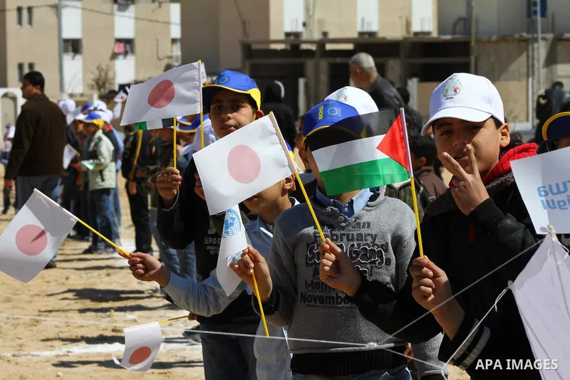 Palestinian children fly kites to show their solidarity with the Japanese people near a Japanese-funded housing project in Khan Younis in the southern Gaza Strip March 18, 2012. The event was organized by the United Nati...