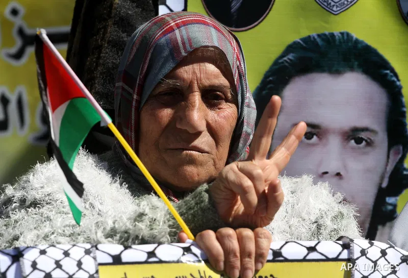 A Palestinian woman hold an image of her son, as she and other protest calling for the release of Palestinian prisoners being held in Israeli jails inside the grounds of the Red Cross headquarters in Gaza City on March 1...
