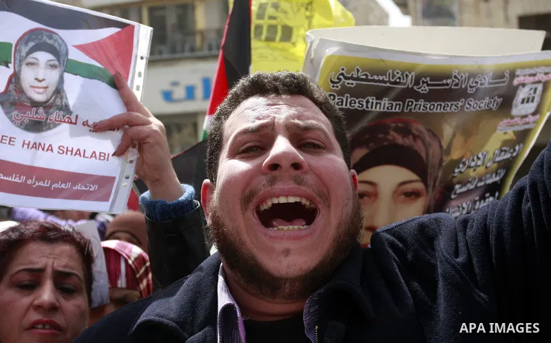 Palestinian women hold portraits of jailed compatriot Hana Shalabi, a female Palestinian prisoner jailed in Israel who has been on hunger strike for 33 days, outside the Red Cross building in the West Bank city of Nablus...