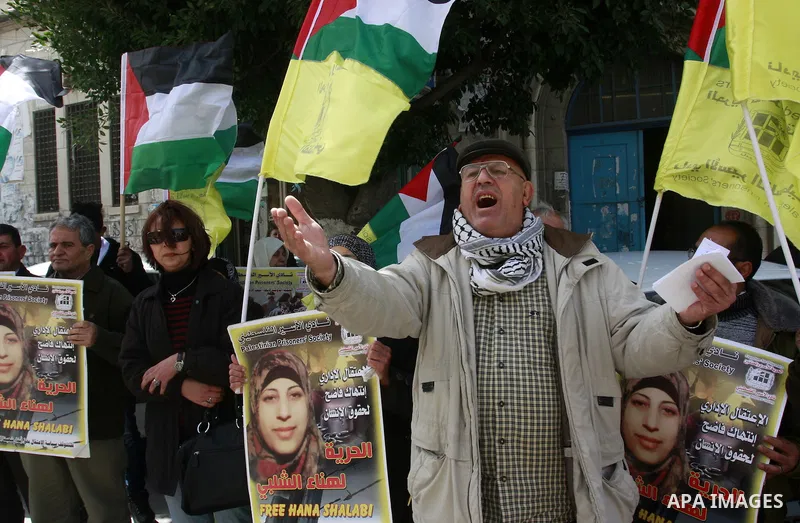 Palestinian women hold portraits of jailed compatriot Hana Shalabi, a female Palestinian prisoner jailed in Israel who has been on hunger strike for 33 days, outside the Red Cross building in the West Bank city of Nablus...