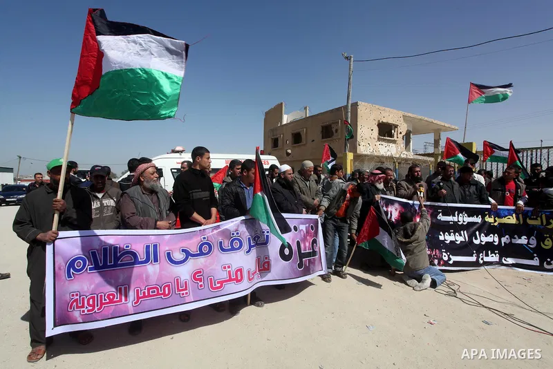 Palestinian demonstrators wave national flags during a protest in the Rafah border crossing with Egypt on March 19, 2012, demanding Egypt provide the Gaza Strip with electricity and fuel. The Palestinian energy authority...